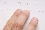 Blind person using brail to read.
