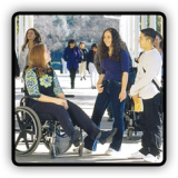 Young people talking, one with a disability sitting in a wheelchair.