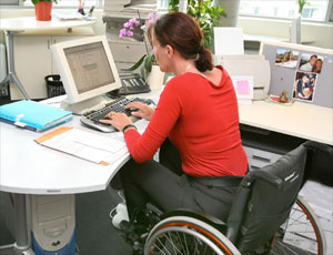 Lady in wheelchair working in office environment.